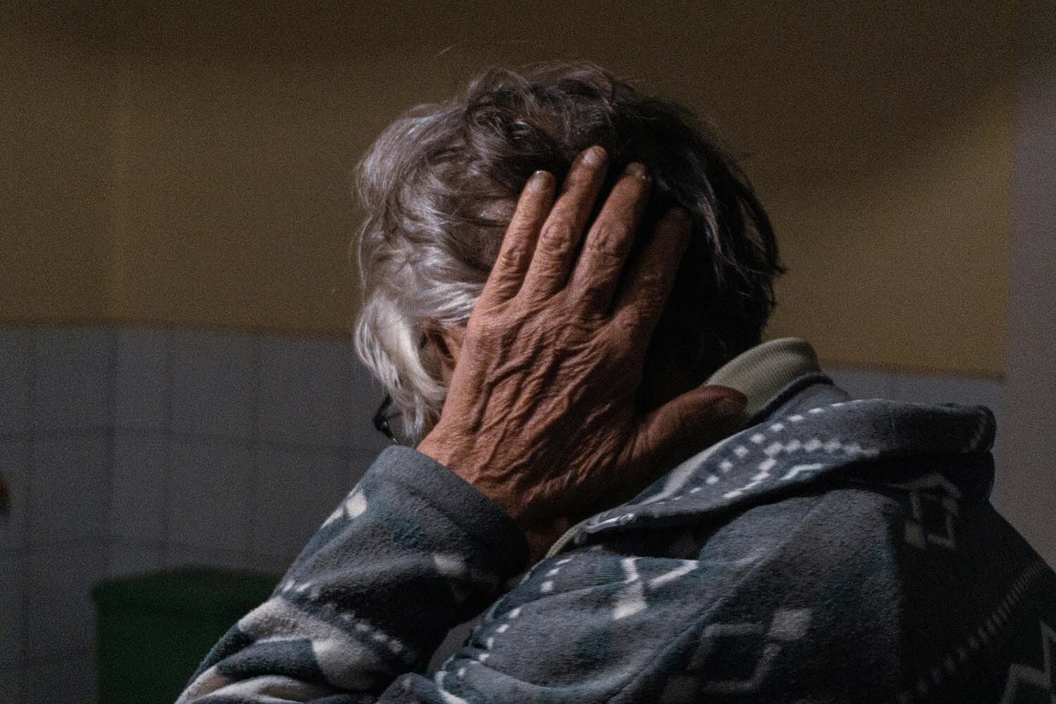 headache an elderly person has her hand on the back of her head